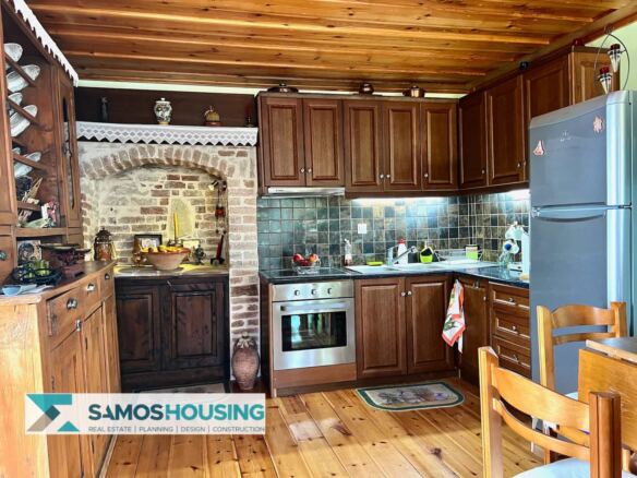 Wooden kitchen with brick and stone arch in a village house in Mitilinioi, Samos