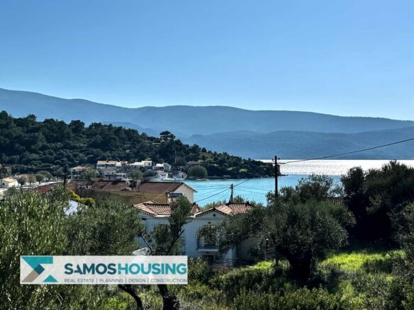 Θέα στη θάλασσα και τα βουνά πάνω από στέγες από οικόπεδο στο Ποσειδώνιο Σάμου