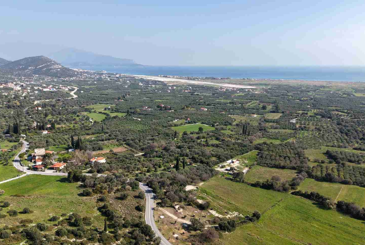 Drone shot of buildable plot SH578 near Chora Samos showing hillside terrain and sea views