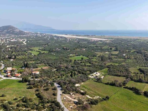 Drone shot of buildable plot SH578 near Chora Samos showing hillside terrain and sea views