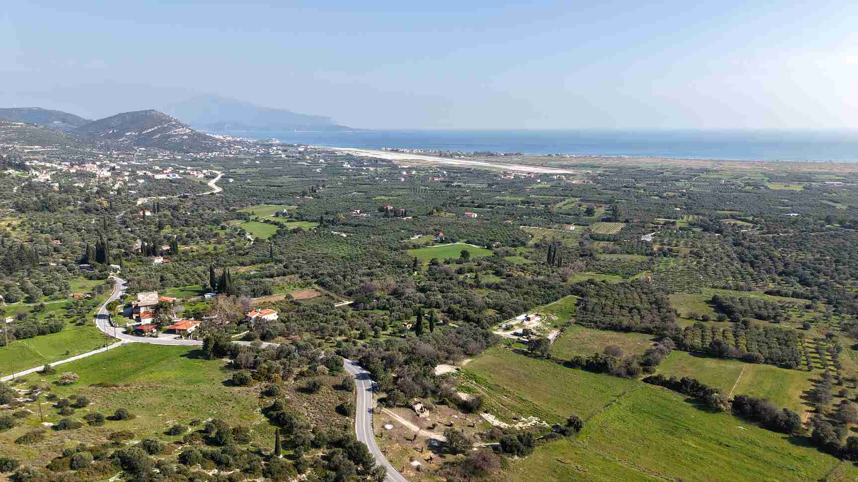 Drone shot of buildable plot SH578 near Chora Samos showing hillside terrain and sea views