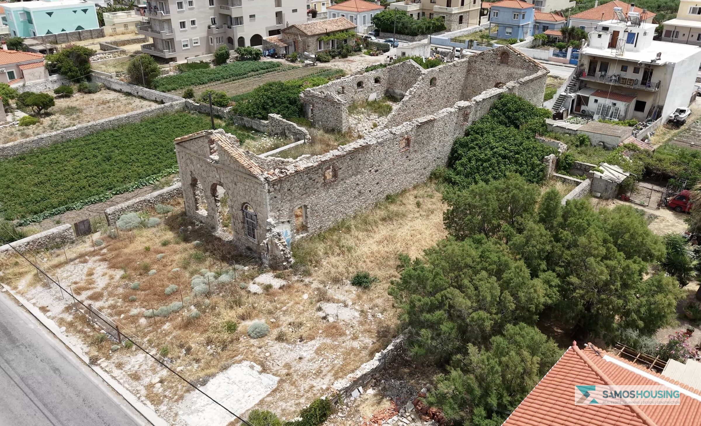 Close aerial view of the roofless stone ruin on the SH589 plot in Karlovasi