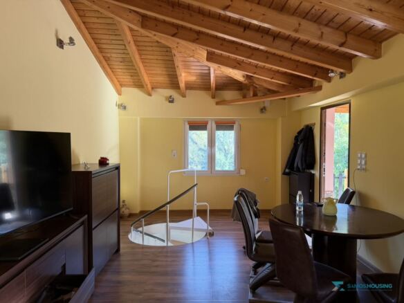 Living room with exposed timber roof beams and spiral stair, Stavrinides