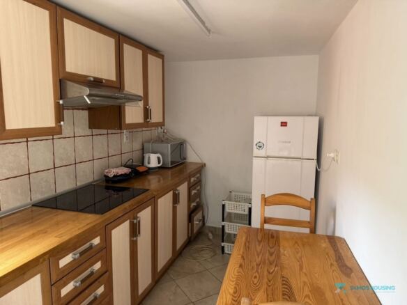 Fitted kitchen with ceramic hob and dining table, Stavrinides house