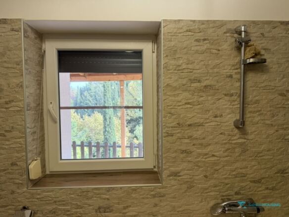 Bathroom window framing the green canyon, Stavrinides, Samos