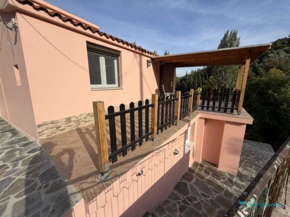 Veranda railing and stone-clad base of the cottage, Stavrinides