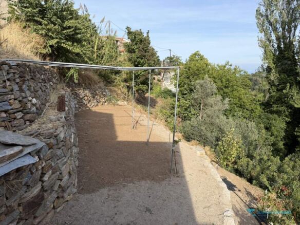Stone-walled terrace with pergola frame near the cottage, Stavrinides